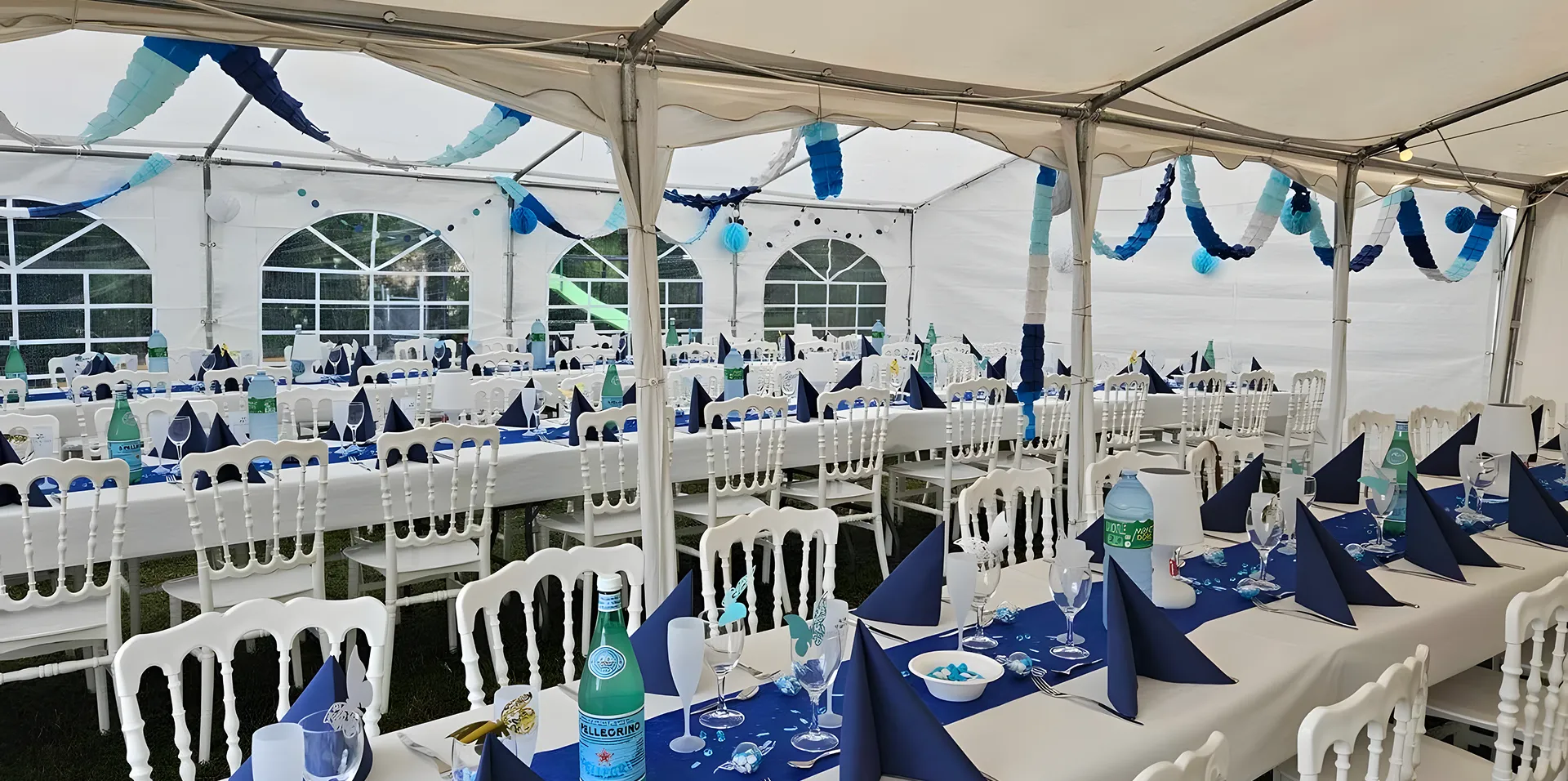 Intérieur de tente décorée de nappes bleues et guirlandes